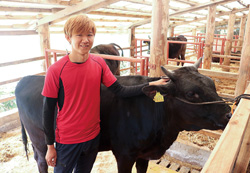 生田さんと飼育している牛の写真