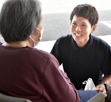 利用者さんと話をする生田さんの様子