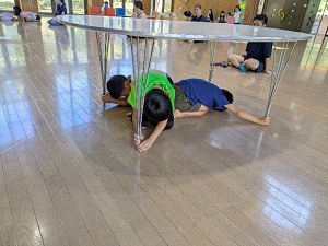 机の下で避難行動をとる状況