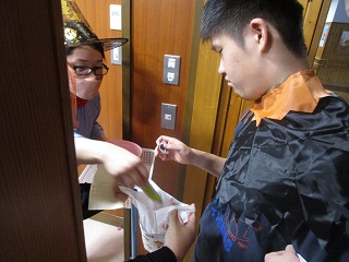 マントを着た子どもがお菓子を受け取る