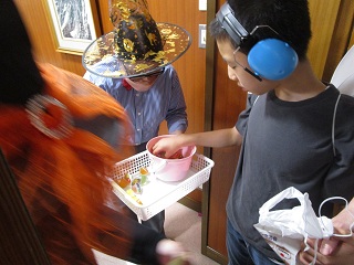 羽を付けた男の子がお菓子を受け取る