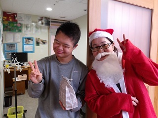 サンタと並んでピースをする児童