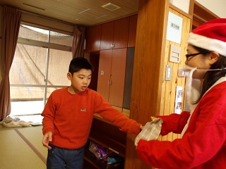 サンタからプレゼントを受け取る児童