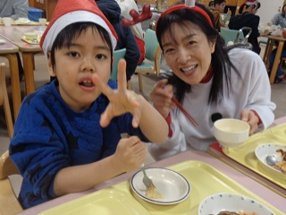 サンタの被り物を付けた児童と職員