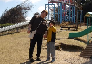 遠くを指さす児童と一緒に眺める職員